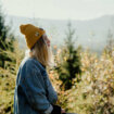 Przypinka z leśnej serii Jeleń duch lasu z kawiatami między porożem wpiety w żółta czapkę dziewczyny o blond włosach od Polskiego producenta emaliowanych przypinek