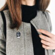Przypinka Audrey Hepburn w czarnych okularach wpięta w szary płaszcz na zamówienie od producenta pinsów Pinswear