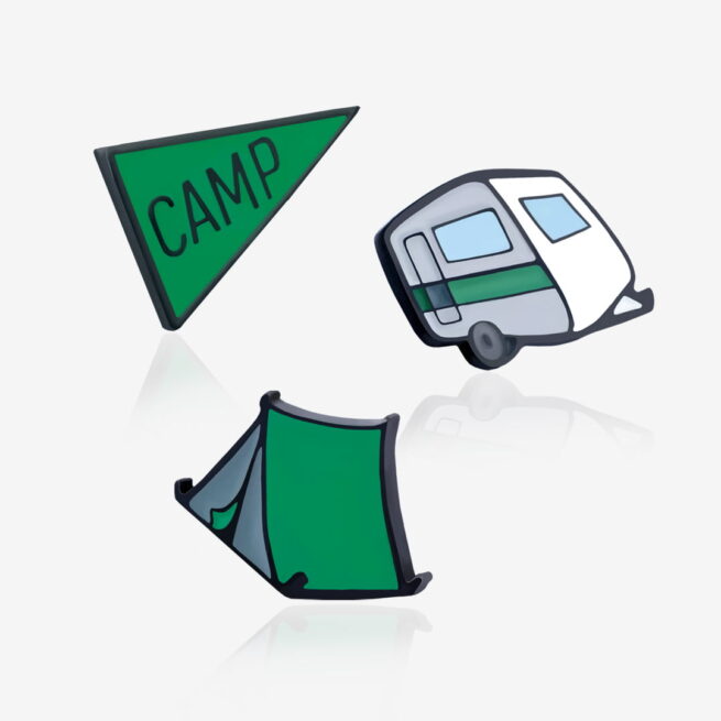 Metalowe przypinki zielony namiot, przyczepa campingowa i flaga "camp"wpiete w szary kaptur chłopaka w okularach od producenta ręcznie malowanych pinow od Pinswear