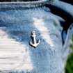 Przypinki metalowe ręcznie malowane wkacyjny motyw kotwica anchor wpieta w jeansowe szorty z przetarciami od Pinswaer Polskiego producenta