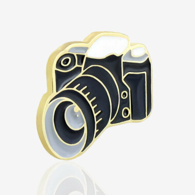 Ręcznie malowany pin aparat lustrzanka od producenta metalowych pinów od Pinswear w kolorze czrno białym wykończony na złoto