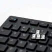 Przypinka metalowa imitująca fragment klawiatury komputera. Pins z napisem WSAD. Ręcznie malowane przypinki w czarnym patynolu malowane na biało.